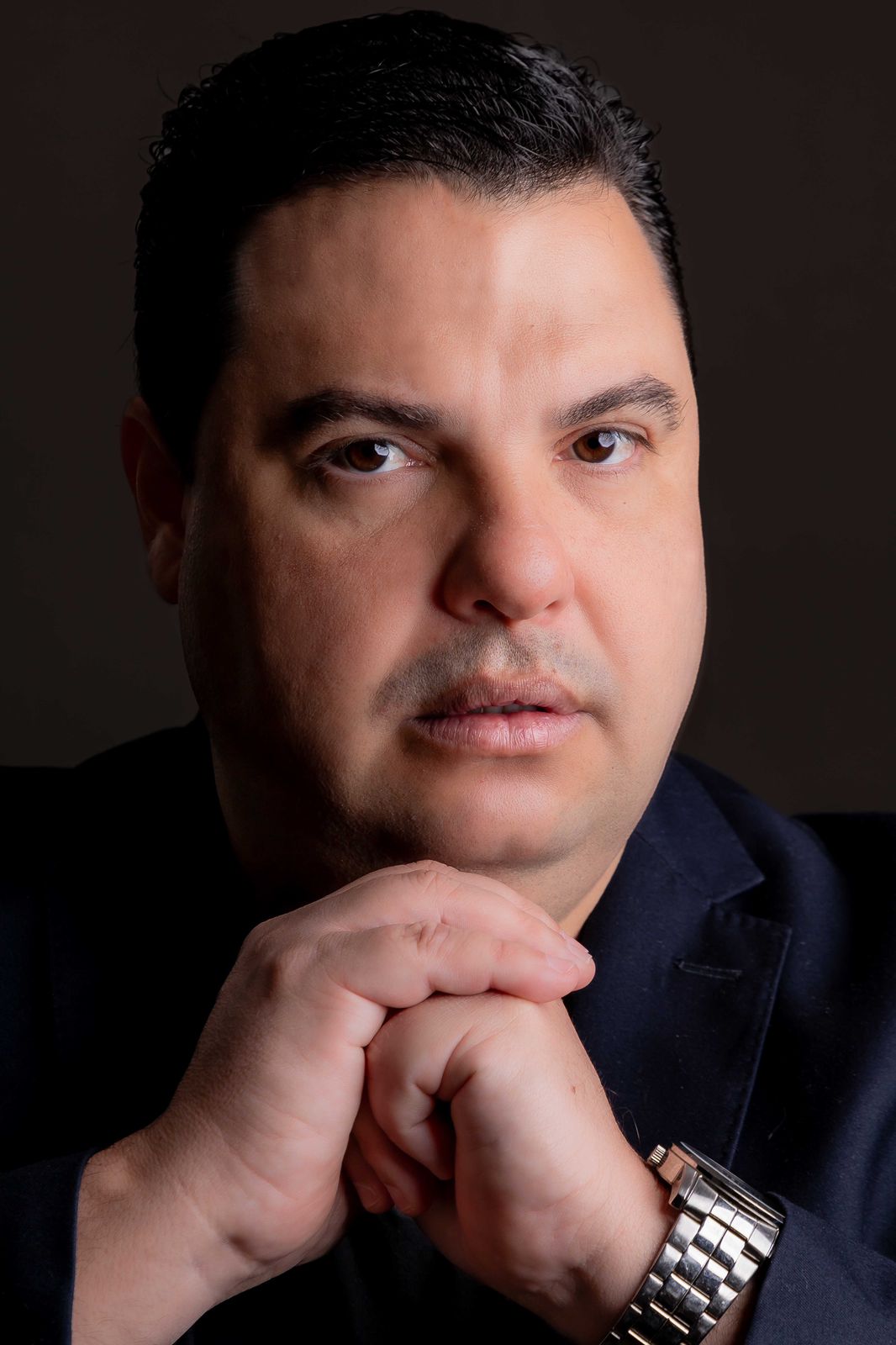 Diogo Garcia olhando diretamente para a câmera, mãos apoiadas sob o queixo